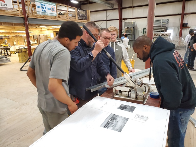 Group of pre-apprentices at the carpenters' training center learning how to form wood replacement products