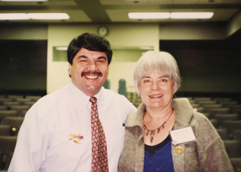 two people standing side by side and smiling