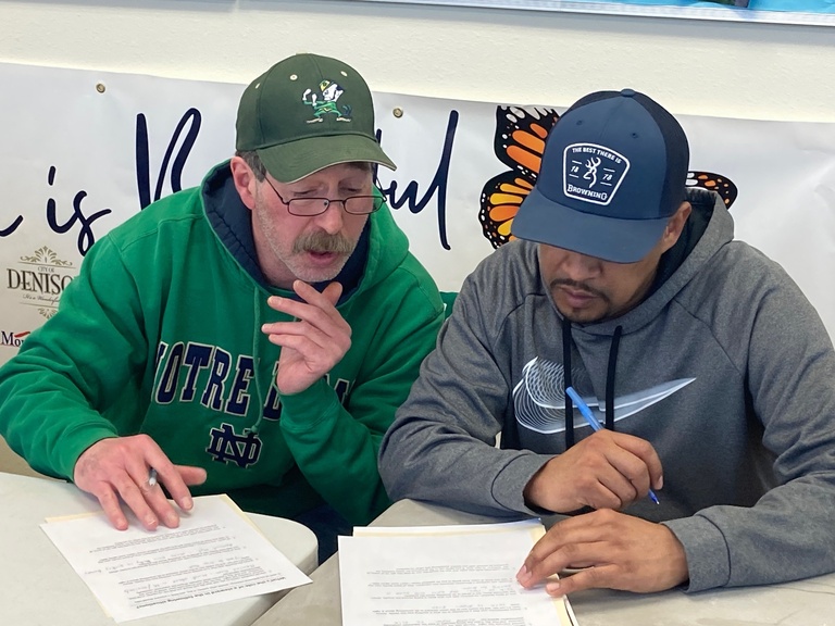Two men reviewing educational materials at Labor Center school