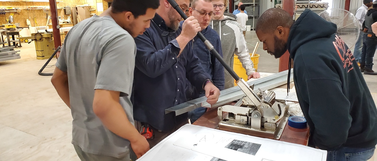 Group of pre-apprentices at the carpenters' training center learning how to form wood replacement products